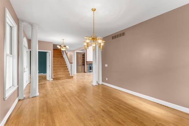 interior space with decorative columns, light hardwood / wood-style flooring, and a chandelier