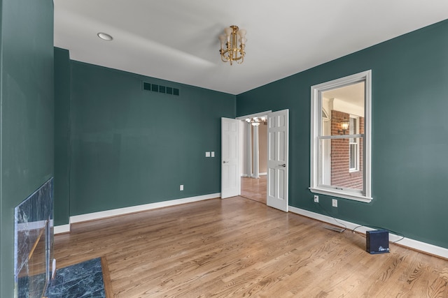 unfurnished bedroom with hardwood / wood-style floors and a chandelier