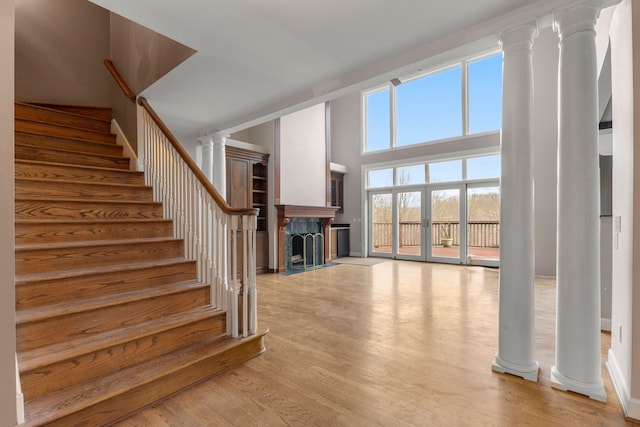 unfurnished living room with a high ceiling and light hardwood / wood-style flooring