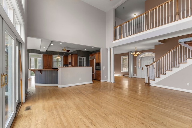 unfurnished living room featuring a wealth of natural light and a towering ceiling