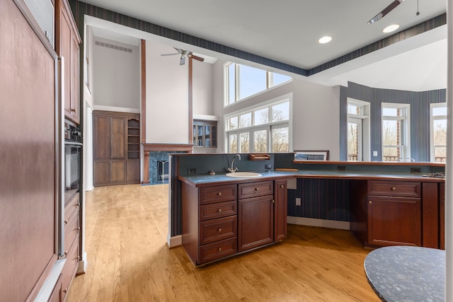 kitchen with light hardwood / wood-style floors, sink, and black oven