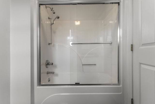 bathroom featuring combined bath / shower with glass door