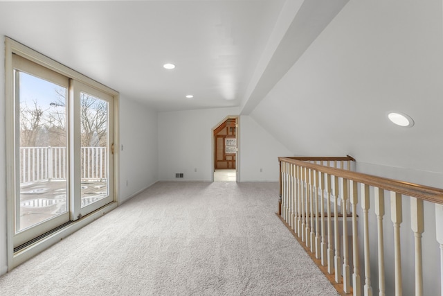 bonus room featuring light colored carpet and vaulted ceiling