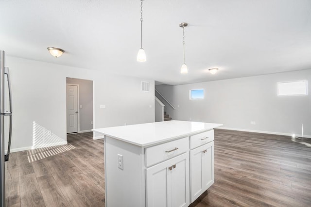 kitchen with hanging light fixtures, white cabinetry, a center island, and dark hardwood / wood-style floors