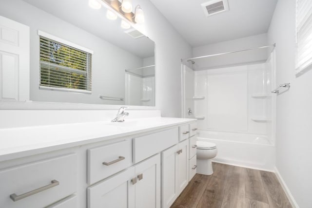 full bathroom featuring vanity, tub / shower combination, hardwood / wood-style floors, and toilet