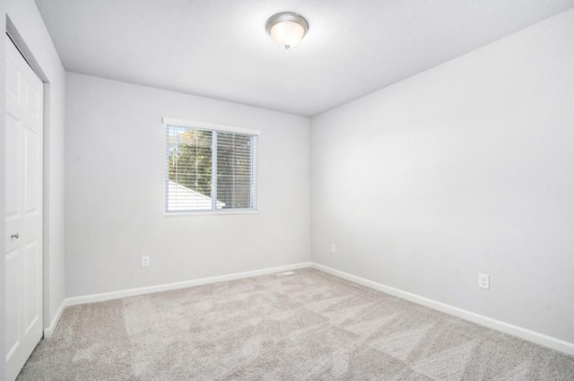 unfurnished room featuring light carpet