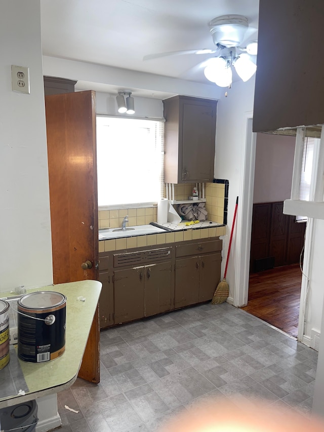 kitchen with backsplash, tile countertops, ceiling fan, and sink