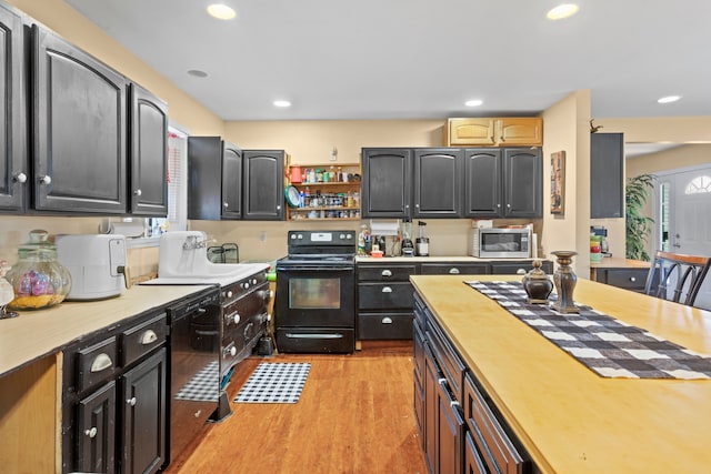 kitchen with light hardwood / wood-style flooring and black appliances