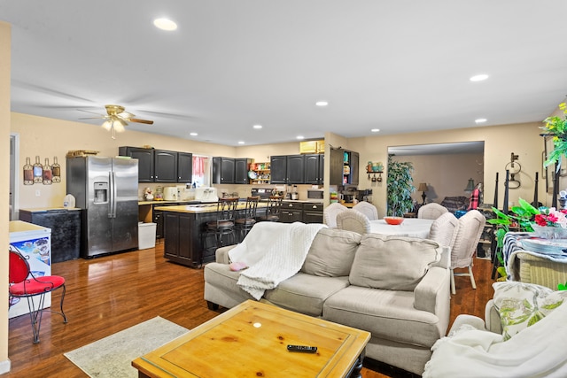 living room with ceiling fan and dark hardwood / wood-style floors