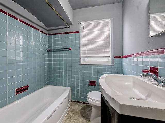 bathroom with vanity, toilet, tile walls, and a tub