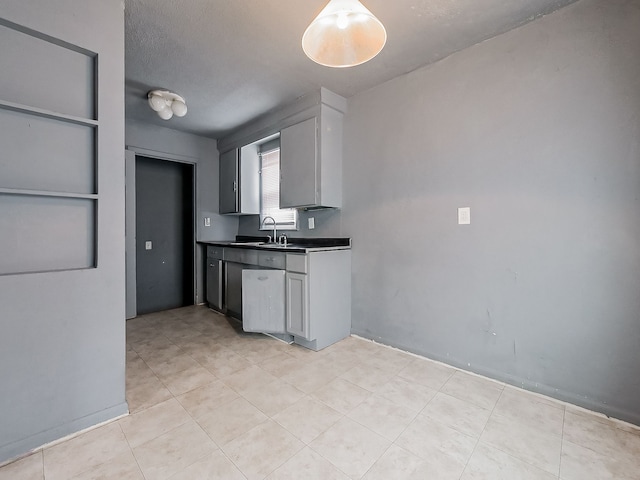 kitchen with a textured ceiling, gray cabinetry, and sink