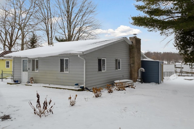 view of snow covered back of property