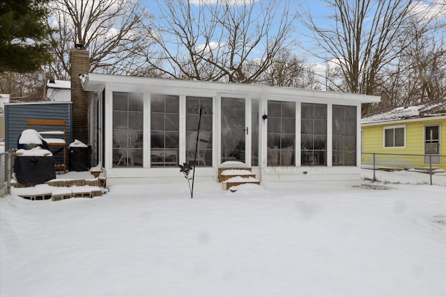 snow covered property featuring a sunroom