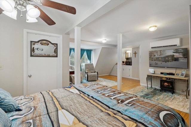 bedroom with an AC wall unit, ceiling fan, and hardwood / wood-style flooring