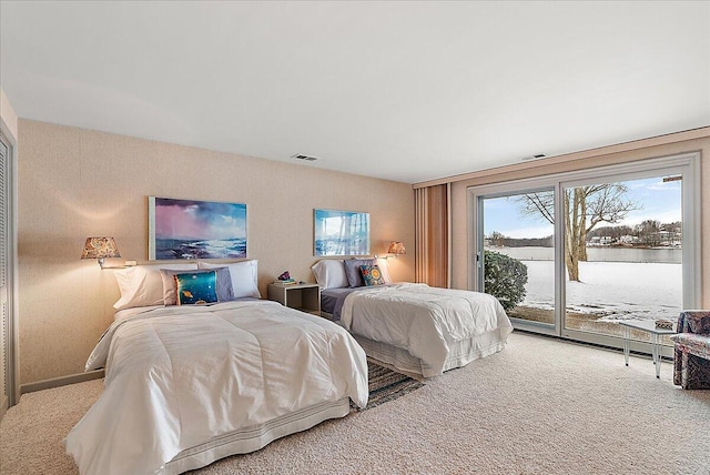 bedroom featuring carpet floors, access to outside, and a water view