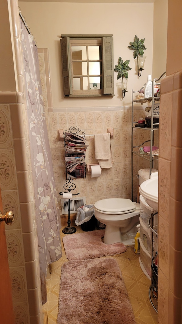 bathroom with toilet and tile walls