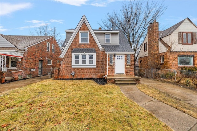 tudor home with a front lawn