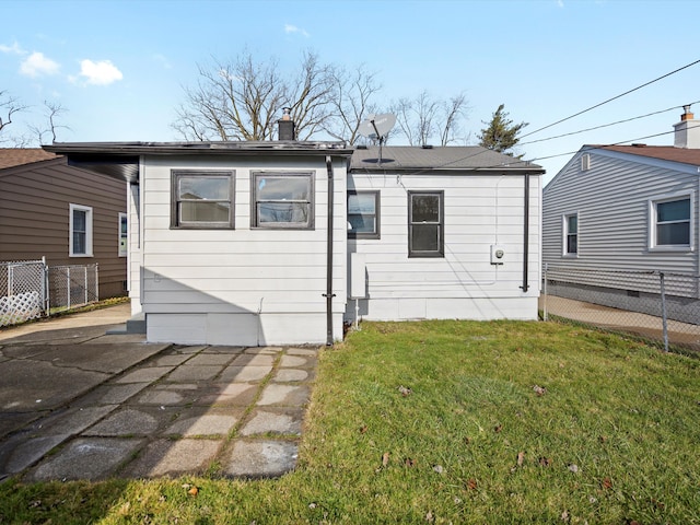 rear view of house featuring a lawn