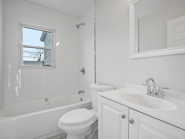 full bathroom featuring tiled shower / bath, vanity, and toilet