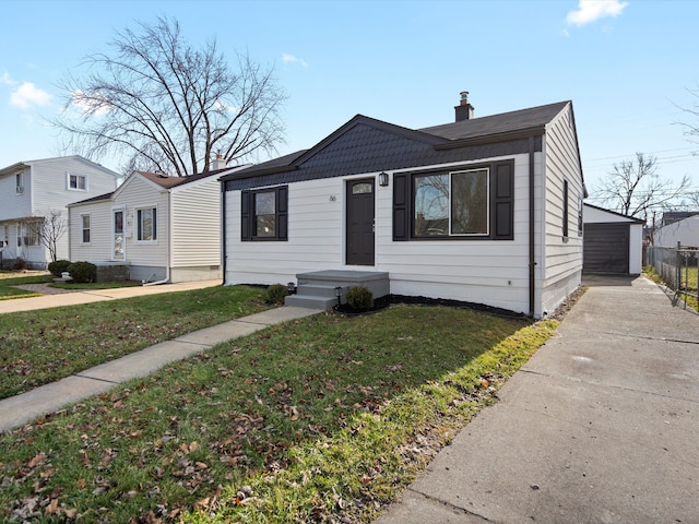 view of front of home with an outbuilding, a garage, and a front lawn