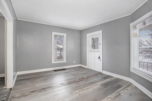 entrance foyer with ornamental molding and hardwood / wood-style floors