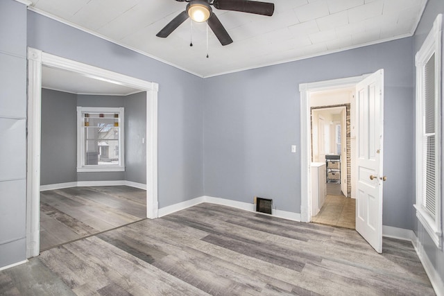 spare room featuring crown molding, light hardwood / wood-style floors, and ceiling fan