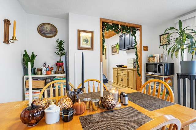 dining room with hardwood / wood-style flooring and a textured ceiling