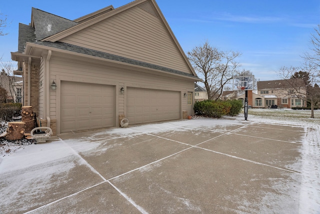 view of home's exterior featuring a garage and roof with shingles