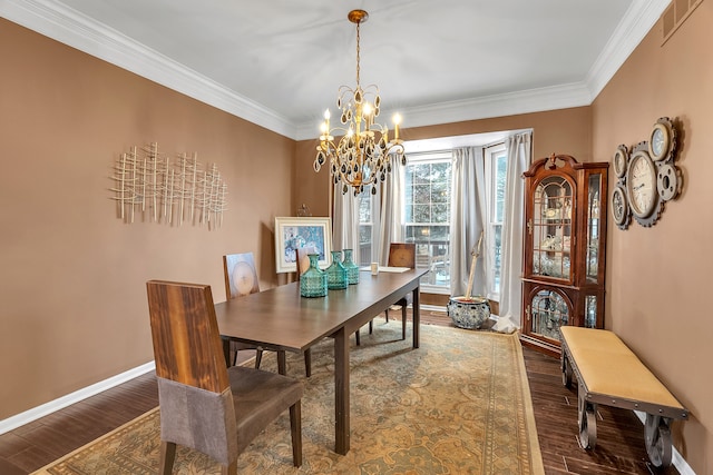 dining room with dark wood-style floors, crown molding, baseboards, and an inviting chandelier