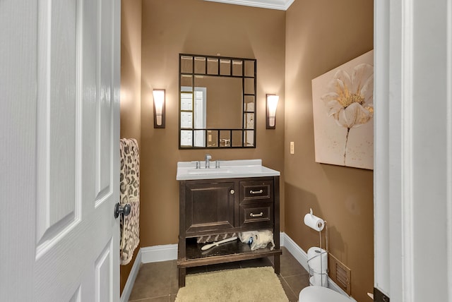 bathroom featuring toilet, vanity, baseboards, and tile patterned floors