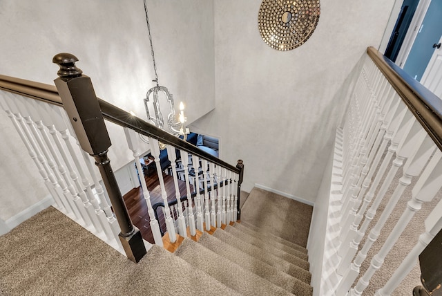 stairway with baseboards and an inviting chandelier