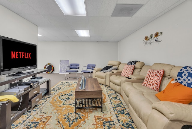 carpeted living area featuring a paneled ceiling