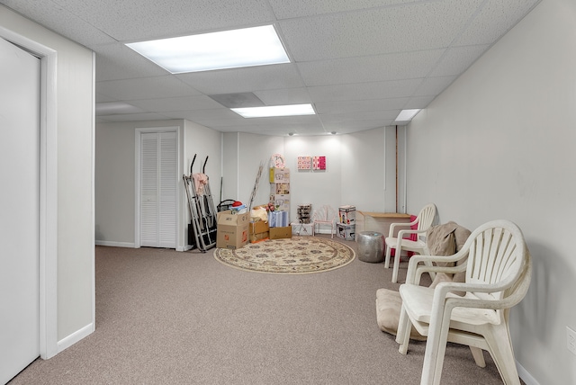 playroom with carpet floors, a paneled ceiling, and baseboards