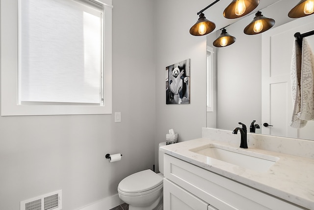 bathroom with vanity, toilet, and a wealth of natural light