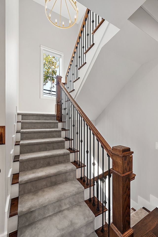 stairs featuring a notable chandelier