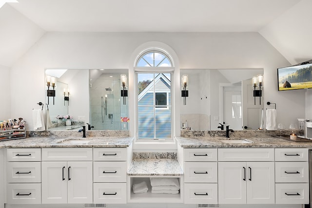 bathroom with vanity, vaulted ceiling, and walk in shower