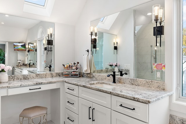 bathroom with vaulted ceiling with skylight, plenty of natural light, and vanity