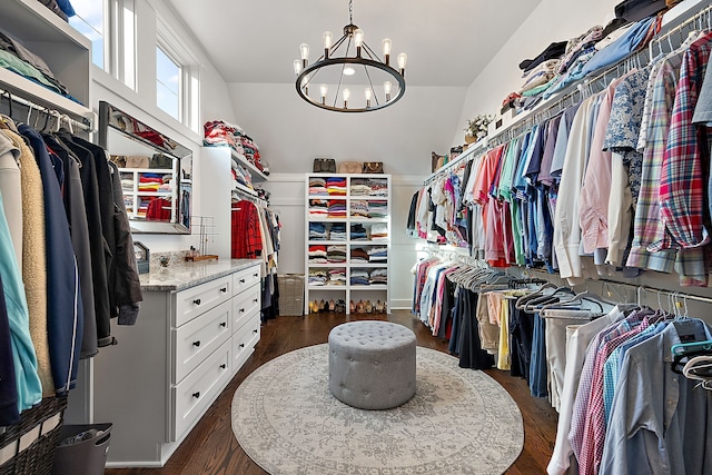 walk in closet featuring dark hardwood / wood-style floors, an inviting chandelier, and lofted ceiling