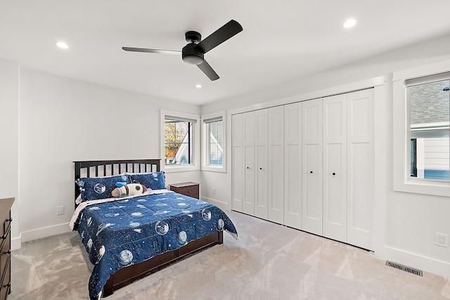 carpeted bedroom with ceiling fan and a closet