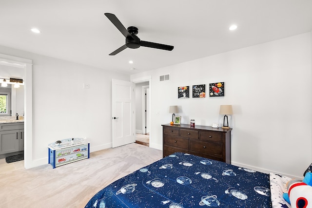 bedroom with ensuite bathroom, ceiling fan, and light colored carpet