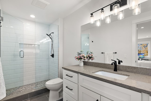 bathroom featuring toilet, vanity, tile patterned floors, and an enclosed shower