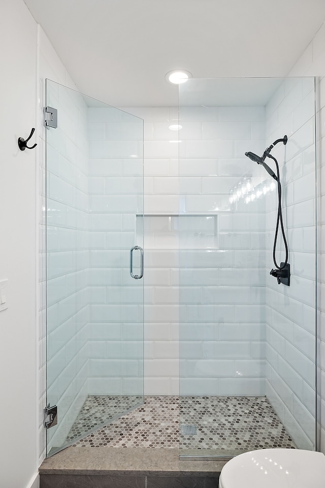 bathroom with toilet and an enclosed shower