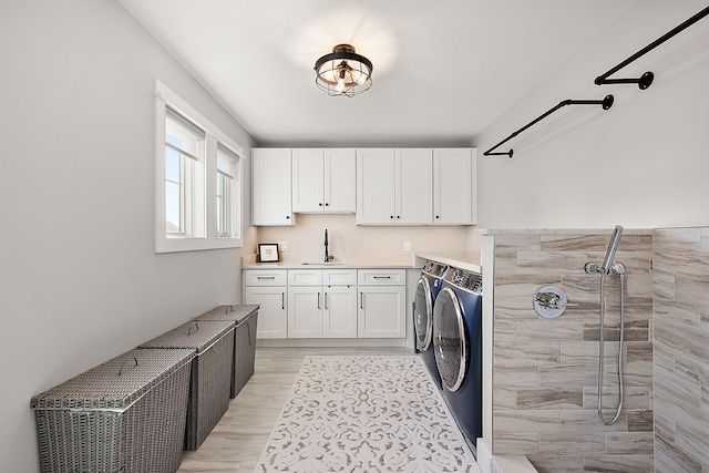 laundry area with washer and clothes dryer, cabinets, and sink