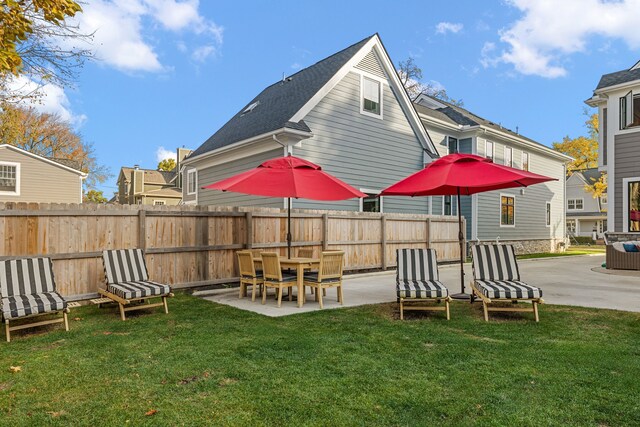 rear view of house featuring a patio area and a yard