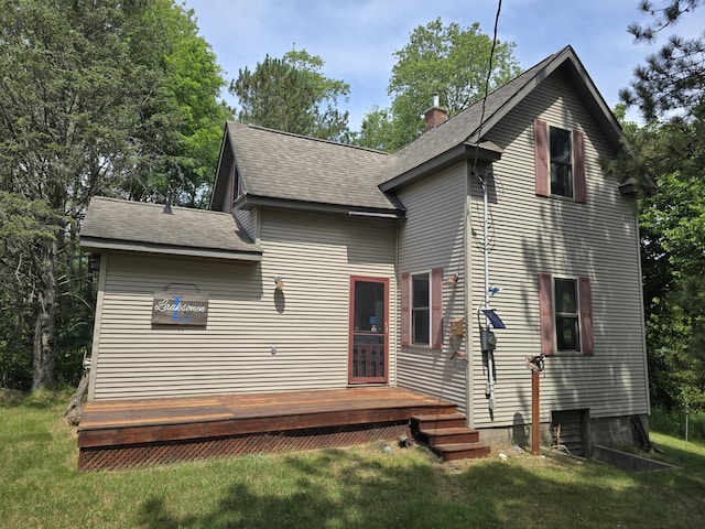 back of property with a yard and a deck