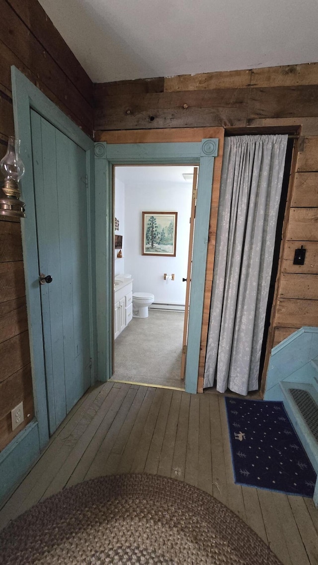 bathroom featuring hardwood / wood-style floors, toilet, and wooden walls