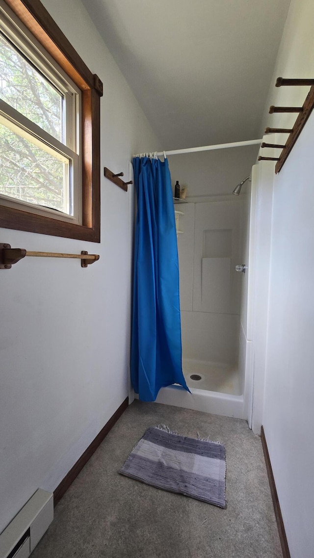 bathroom featuring a shower with shower curtain and a baseboard heating unit