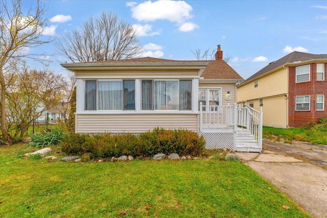 bungalow-style house featuring a front lawn