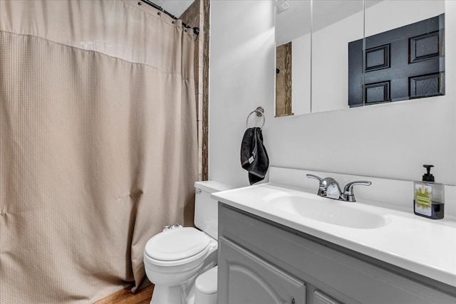 bathroom featuring walk in shower, vanity, and toilet