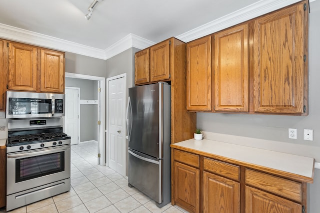 kitchen featuring rail lighting, light tile patterned floors, ornamental molding, and appliances with stainless steel finishes